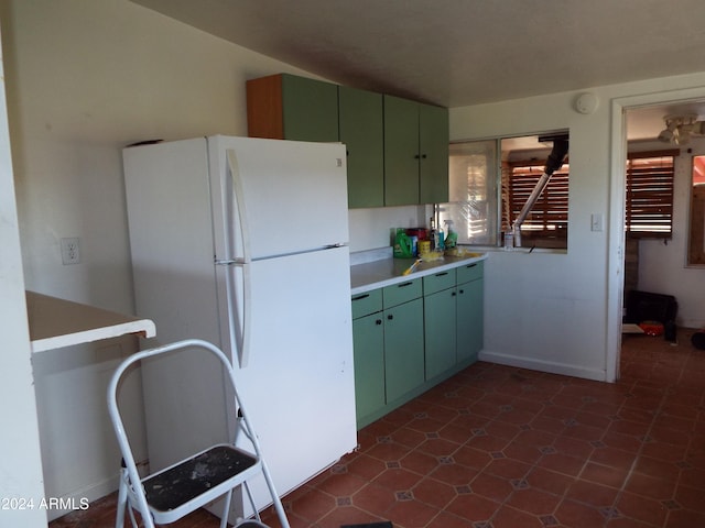 kitchen with green cabinets and white fridge