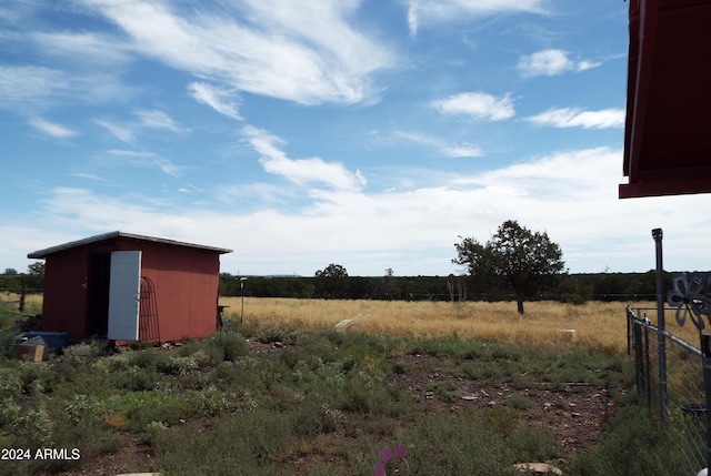 view of yard with a shed and a rural view