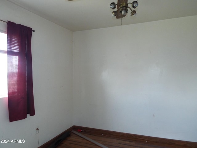 empty room with an inviting chandelier and hardwood / wood-style flooring