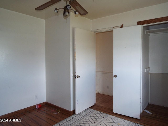 unfurnished bedroom with a closet, wood-type flooring, and ceiling fan