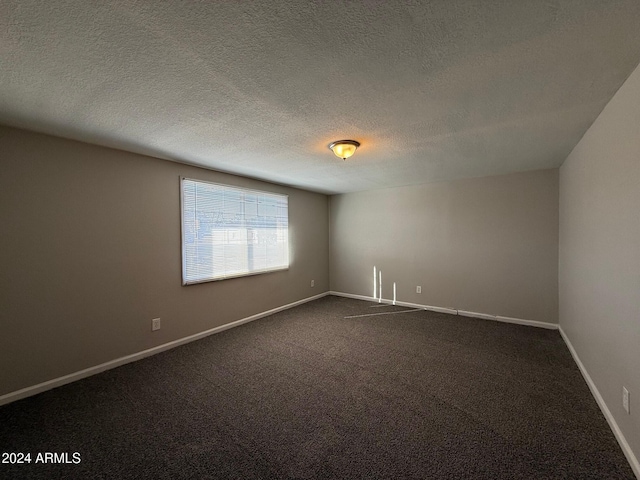 carpeted empty room with a textured ceiling