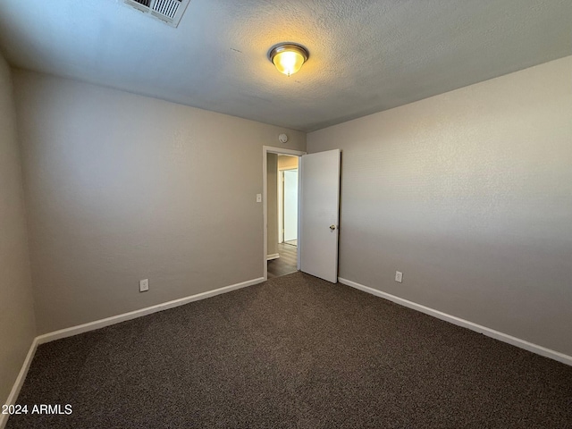 unfurnished room featuring dark colored carpet