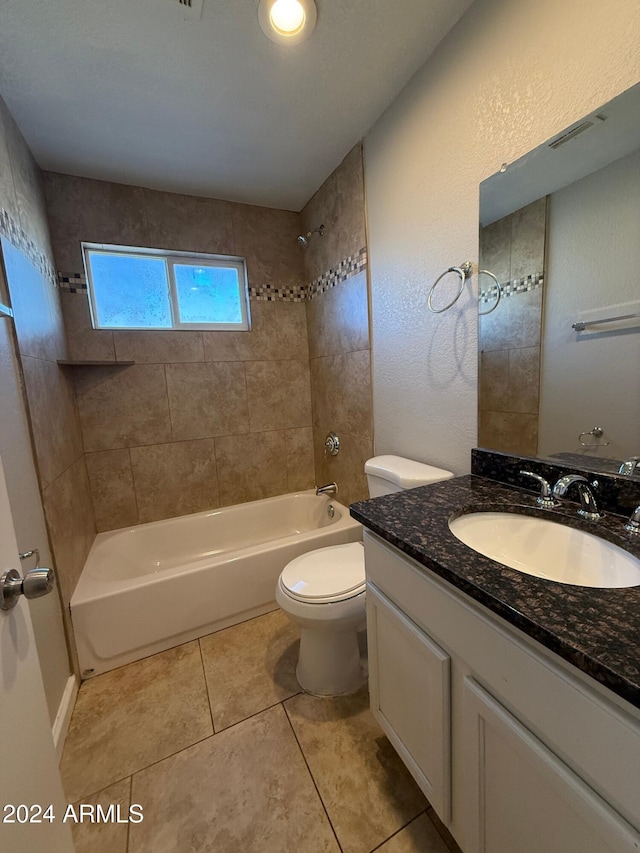 full bathroom with tile patterned floors, vanity, tiled shower / bath combo, and toilet