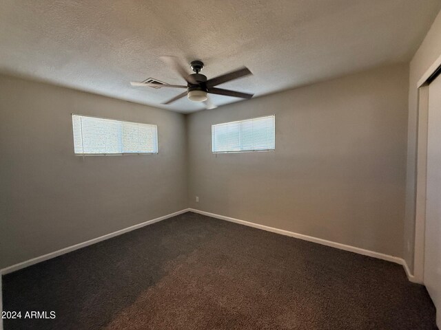 carpeted spare room with ceiling fan and a textured ceiling