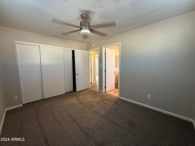 unfurnished bedroom featuring ceiling fan, a closet, light colored carpet, and a textured ceiling