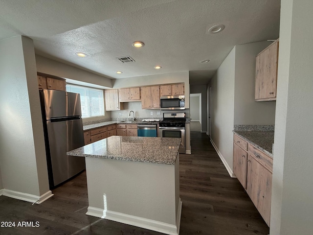 kitchen featuring light stone countertops, appliances with stainless steel finishes, a textured ceiling, and dark wood-type flooring