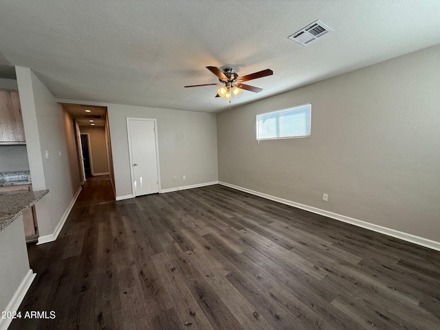 interior space featuring ceiling fan, dark wood-type flooring, and a textured ceiling