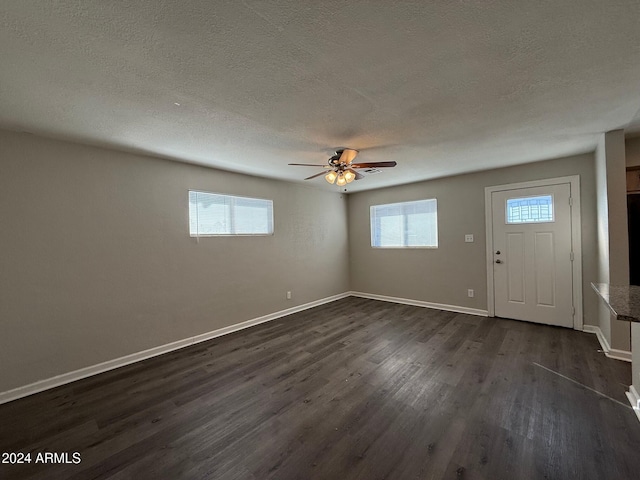 foyer entrance with ceiling fan, dark hardwood / wood-style flooring, a textured ceiling, and a wealth of natural light