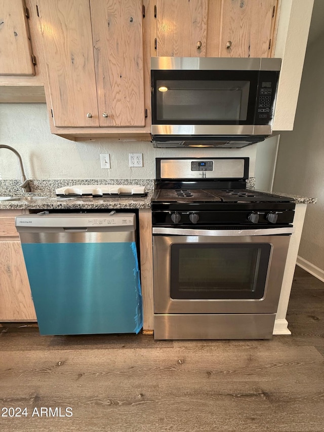 kitchen with sink, light brown cabinets, stainless steel appliances, and hardwood / wood-style flooring