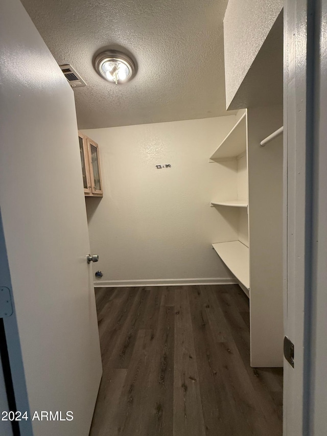 walk in closet with dark hardwood / wood-style floors