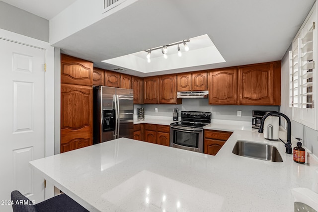 kitchen with stainless steel appliances, a raised ceiling, sink, and kitchen peninsula