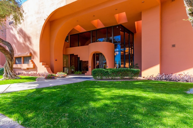 entrance to property with a lawn