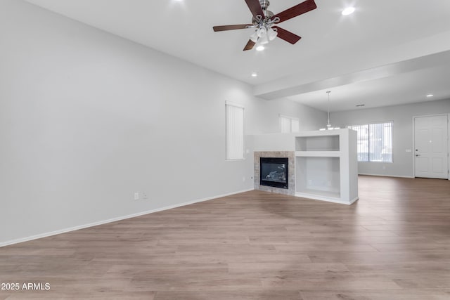 unfurnished living room featuring light hardwood / wood-style flooring and ceiling fan