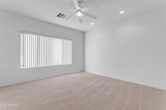 unfurnished room featuring ceiling fan, a wealth of natural light, and light colored carpet