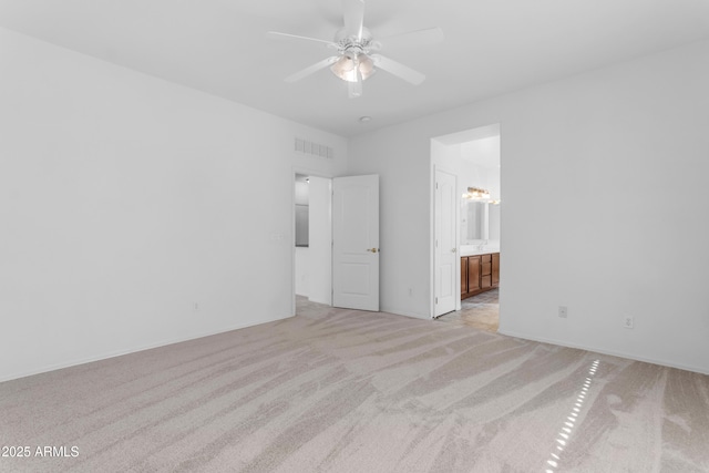 unfurnished bedroom with ceiling fan, light carpet, and ensuite bath