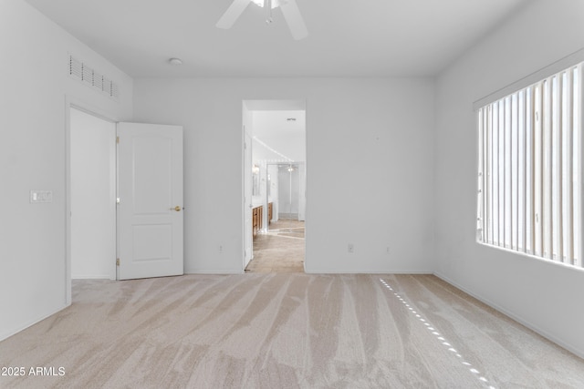 spare room featuring plenty of natural light, light colored carpet, and ceiling fan