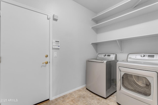 laundry area featuring light tile patterned floors and washing machine and dryer