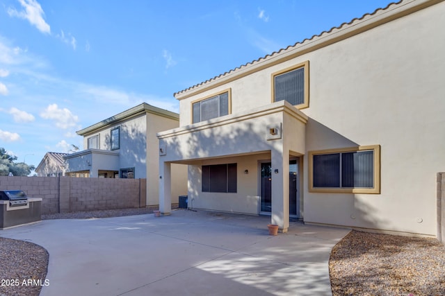 rear view of property featuring a patio area