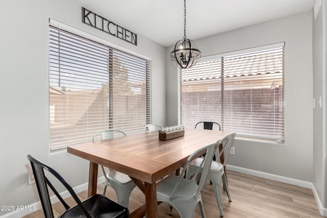 dining space featuring light hardwood / wood-style flooring, a wealth of natural light, and a chandelier