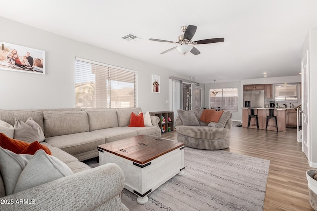 living room with light hardwood / wood-style floors and ceiling fan