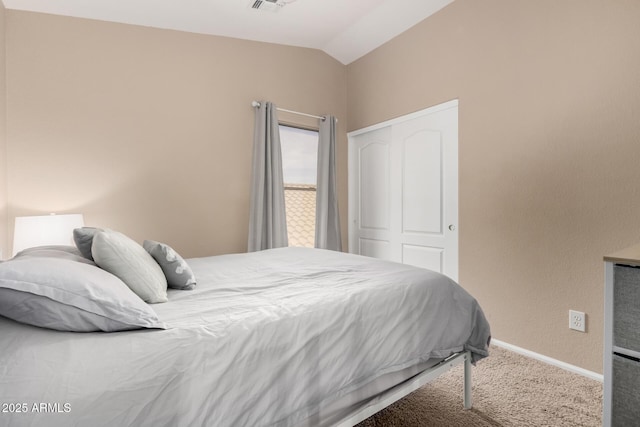 carpeted bedroom featuring vaulted ceiling and a closet