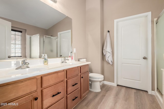 bathroom featuring lofted ceiling, hardwood / wood-style flooring, vanity, a shower with shower door, and toilet