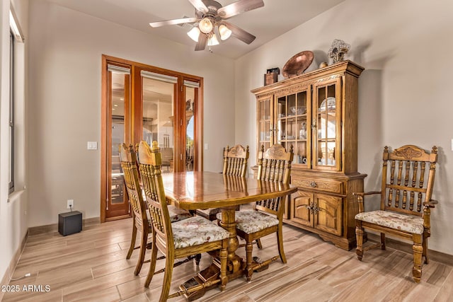 dining area with light wood finished floors, baseboards, and ceiling fan