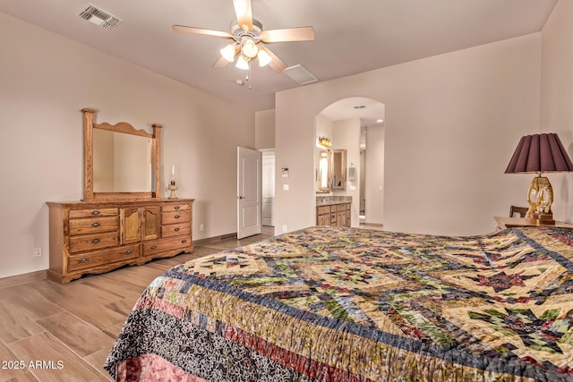 bedroom with visible vents, baseboards, ceiling fan, arched walkways, and light wood-style floors