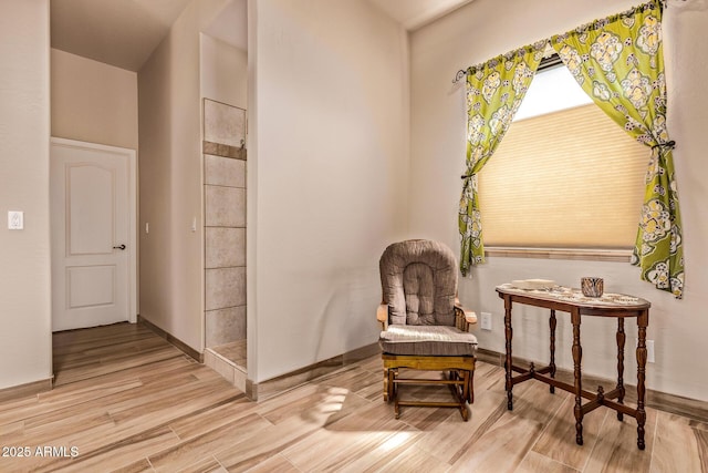living area featuring baseboards and wood finished floors