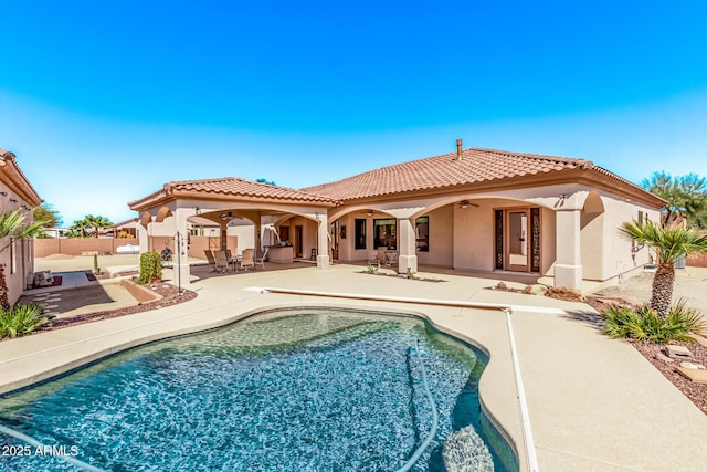 rear view of house with ceiling fan, stucco siding, a tiled roof, and a patio