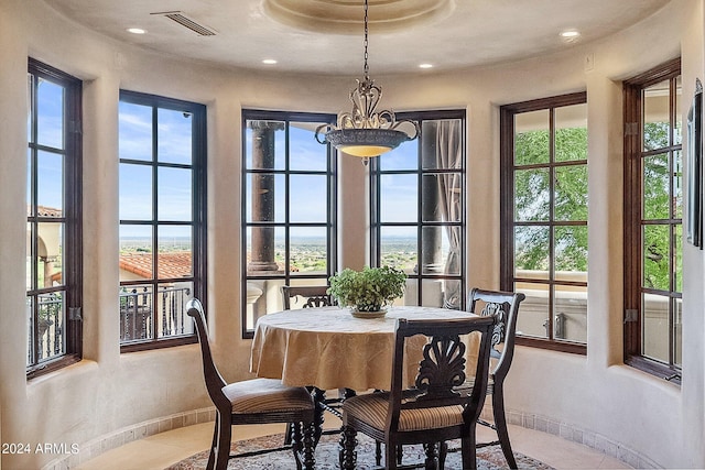 tiled dining area with a chandelier