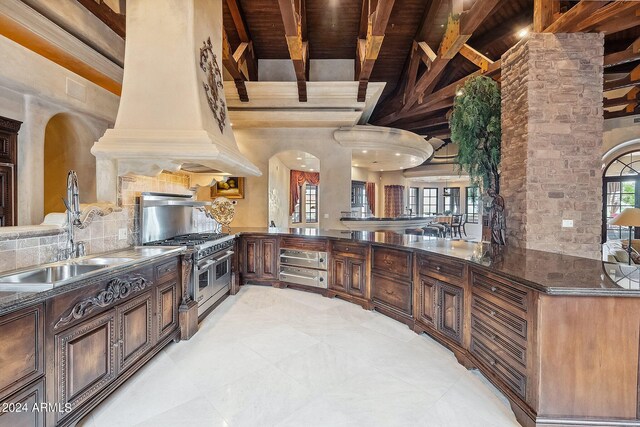 interior space with built in shelves, beamed ceiling, a high ceiling, and wood ceiling