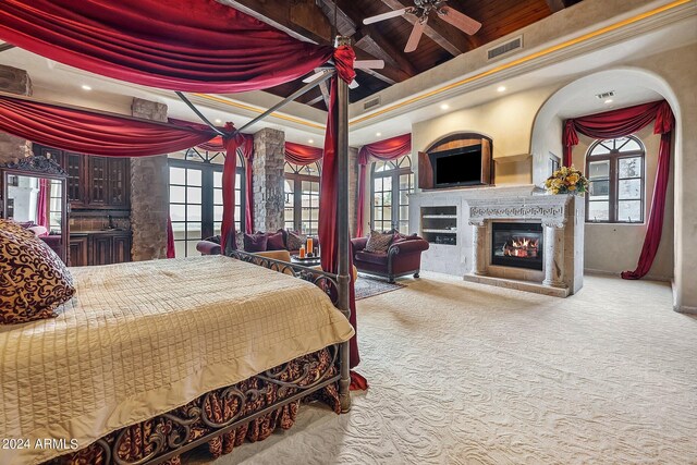 carpeted bedroom featuring a towering ceiling, beam ceiling, wood ceiling, and ceiling fan