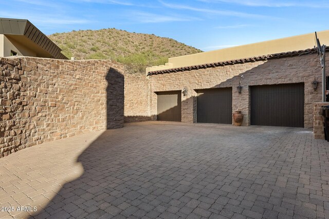 mediterranean / spanish home featuring a garage, a balcony, and a mountain view