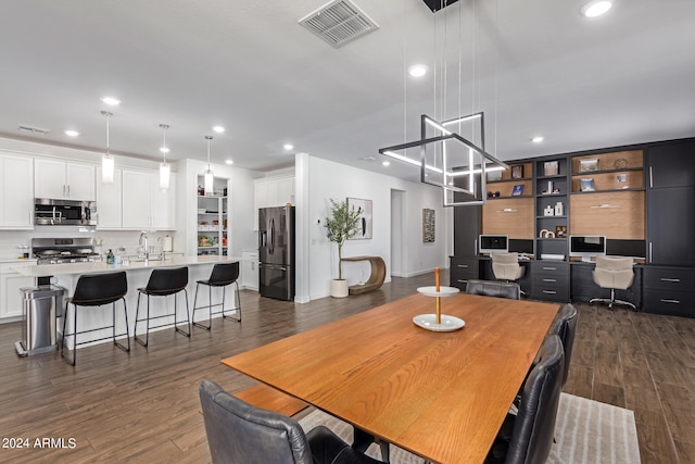 dining area with dark hardwood / wood-style floors and sink