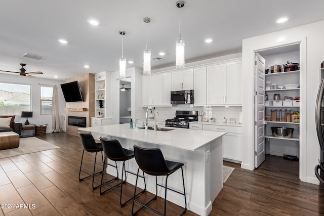 kitchen featuring ceiling fan, white cabinets, stainless steel appliances, and dark wood-type flooring