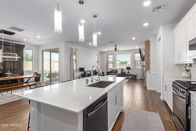 kitchen featuring ceiling fan, an island with sink, sink, white cabinetry, and appliances with stainless steel finishes