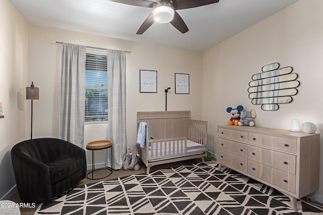 bedroom with a crib and ceiling fan