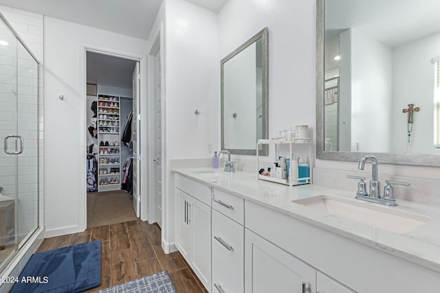 bathroom with walk in shower, vanity, and hardwood / wood-style flooring