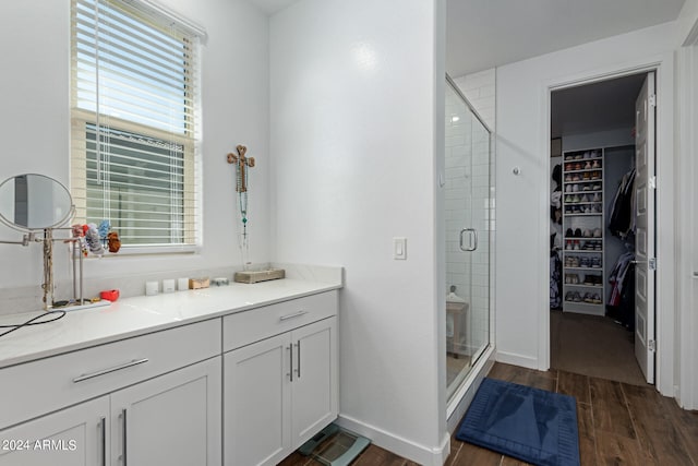 bathroom featuring walk in shower, vanity, and hardwood / wood-style floors