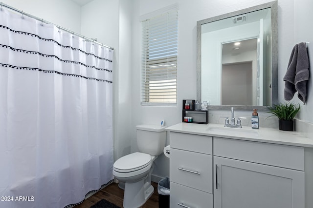 bathroom with curtained shower, wood-type flooring, vanity, and toilet