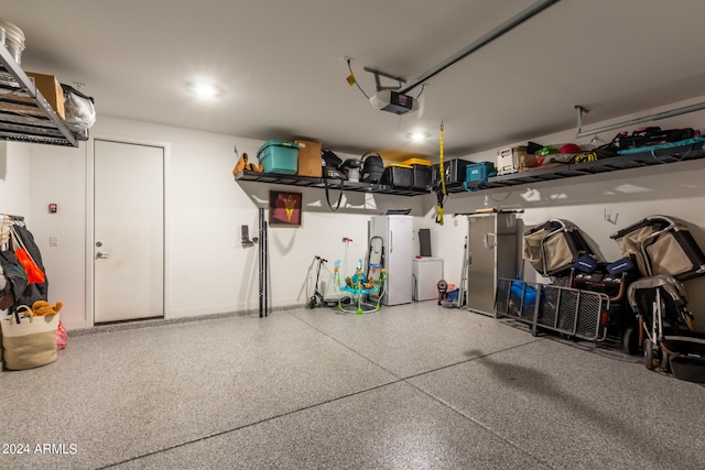 garage with a garage door opener and white fridge