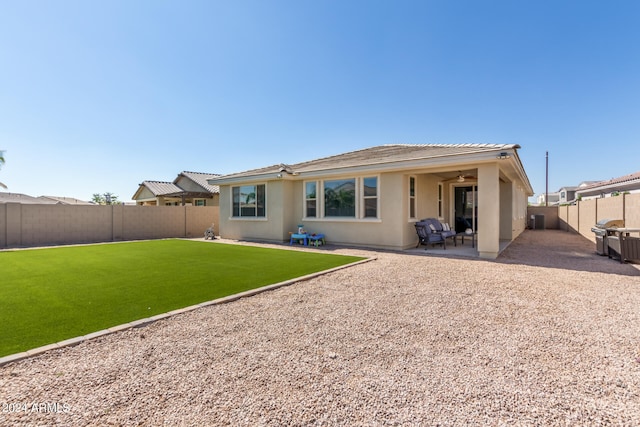 back of property with a lawn and a patio area