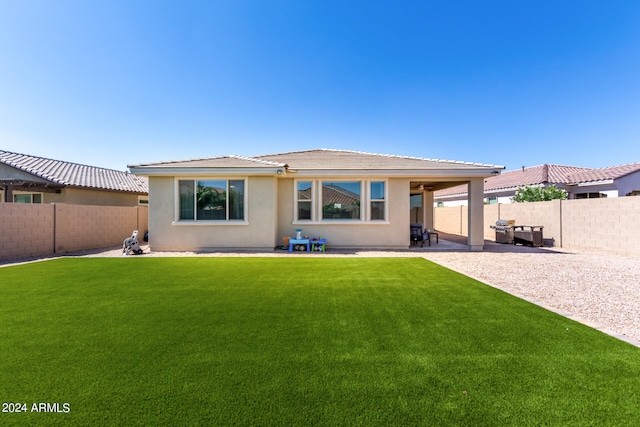 rear view of property with a patio and a yard