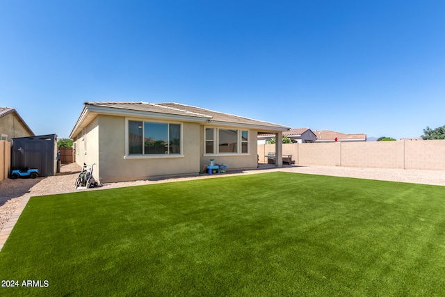 rear view of property with a yard and a patio area