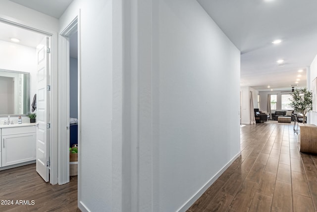 corridor with dark hardwood / wood-style floors and sink