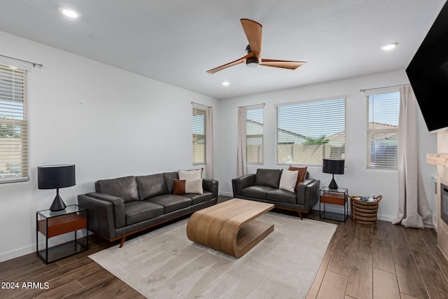 living room with ceiling fan, a fireplace, and dark hardwood / wood-style flooring