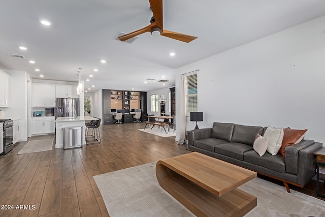 living room with wood-type flooring and ceiling fan