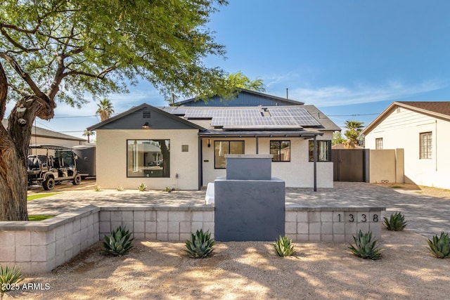 1338 E Granada Rd, Phoenix, AZ 85006 - rear view of house with a gate, roof mounted solar panels, and stucco siding