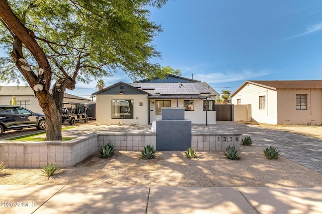 1338 E Granada Rd, Phoenix, AZ 85006 - view of front facade featuring a fenced front yard, roof mounted solar panels, a gate, stucco siding, and driveway